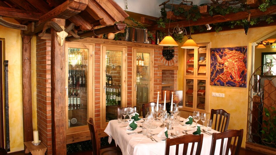 Helles Restaurant mit einem eleganten Tisch, Weinregalen und rustikalen Holzelementen.