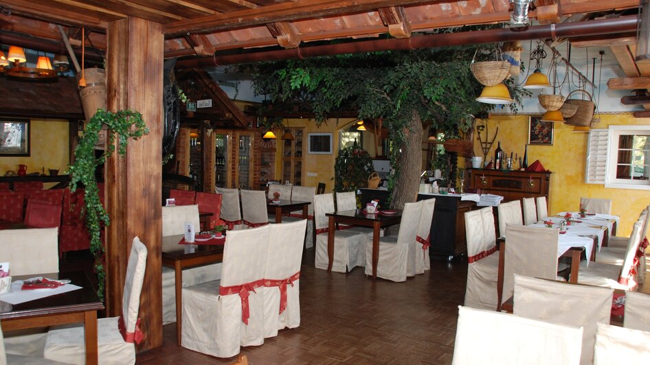 Gemütliches Restaurant mit Holzdekor und Pflanzen.