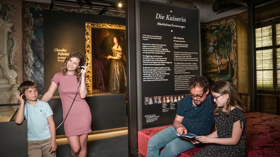 Familie betrachtet Kunst im Schloss Eggenberg, hört Infos über Kaiserin.