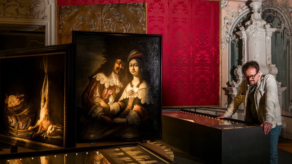Ein Mann betrachtet Gemälde im Schloss Eggenberg.