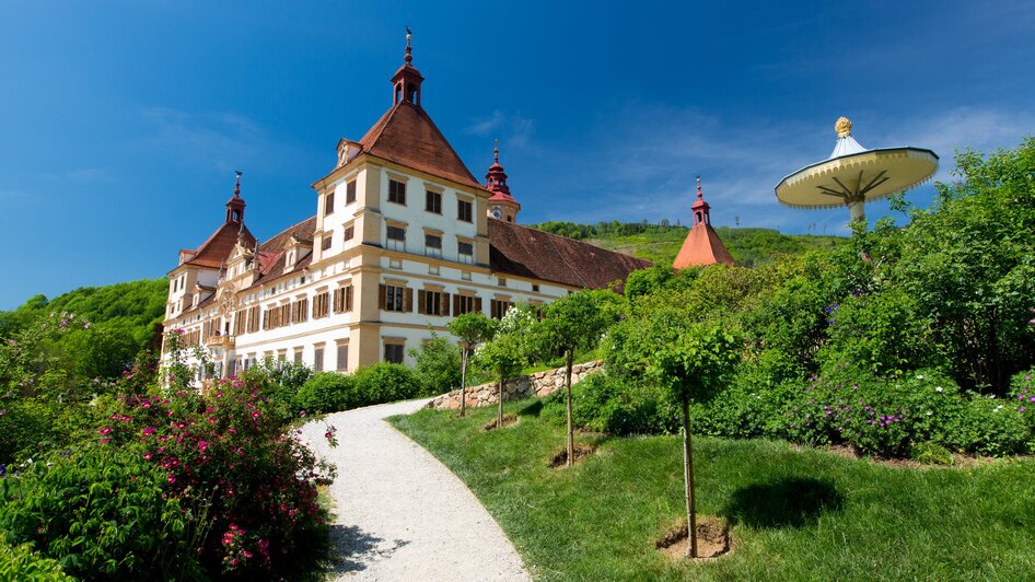 Schloss Eggenberg in Graz, umgeben von Natur und blühenden Gärten.