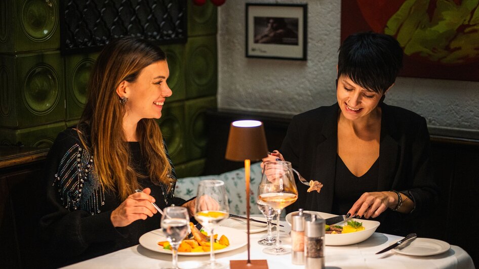 Zwei Frauen genießen ein Abendessen im Gasthaus Stainzerbauer in Graz.