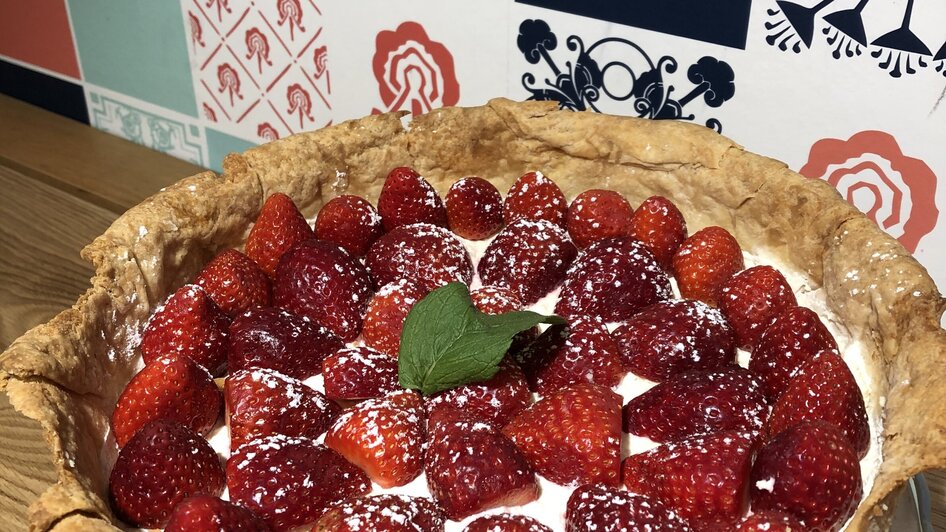 Leckere Torte mit frischen Erdbeeren, Sahne und Minze.