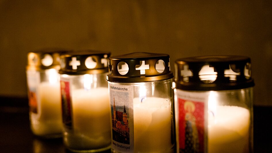 Fünf brennende Kerzen mit Etiketten in der Wallfahrtskirche. | © TV Region OberGraz-Mias Photoart