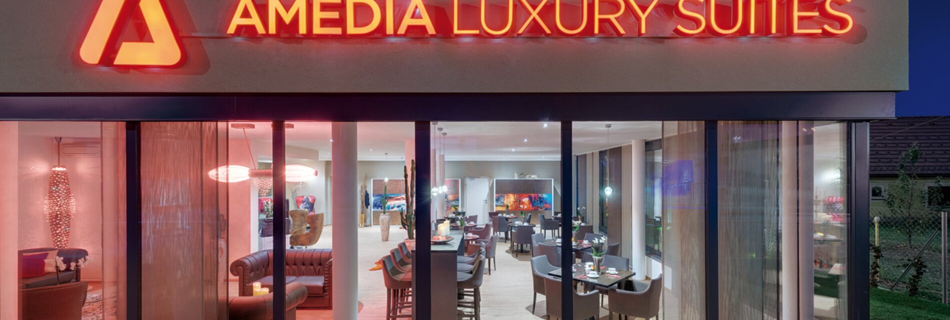 Die Außenansicht des Amedia Luxury Suites in Graz, beleuchtet und modern.