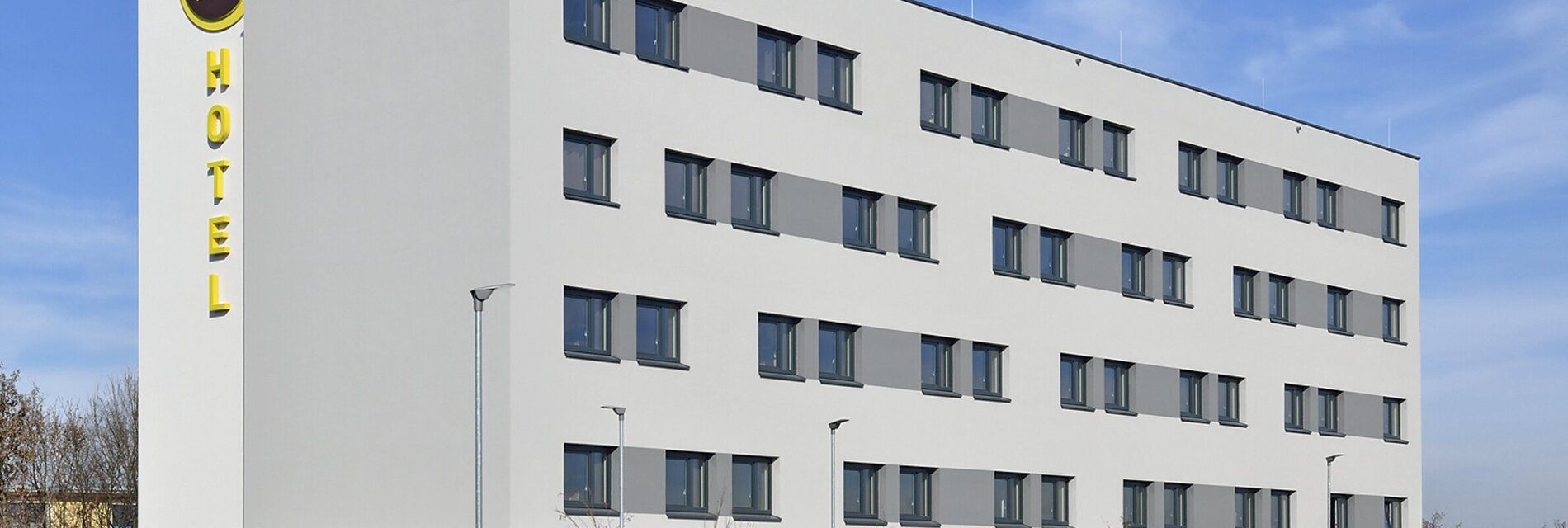 Fassade des B&B Hotels Graz City Süd bei klarem Himmel.