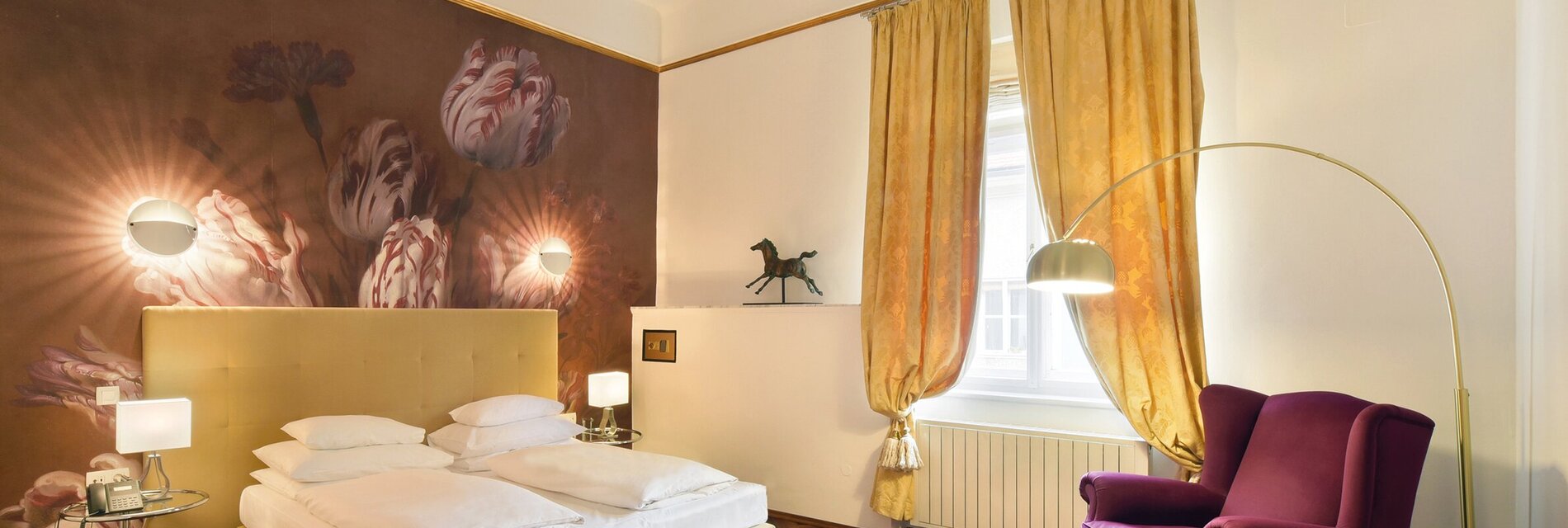 Ein elegantes Hotelzimmer mit einem klassischen Bett und einer schönen Wandmalerei.