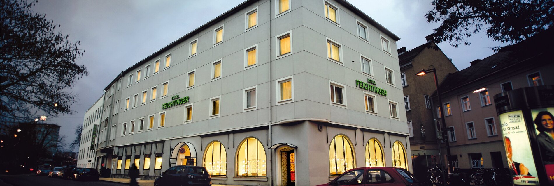 Außenansicht des Hotel Feichtinger mit beleuchteten Fenstern.