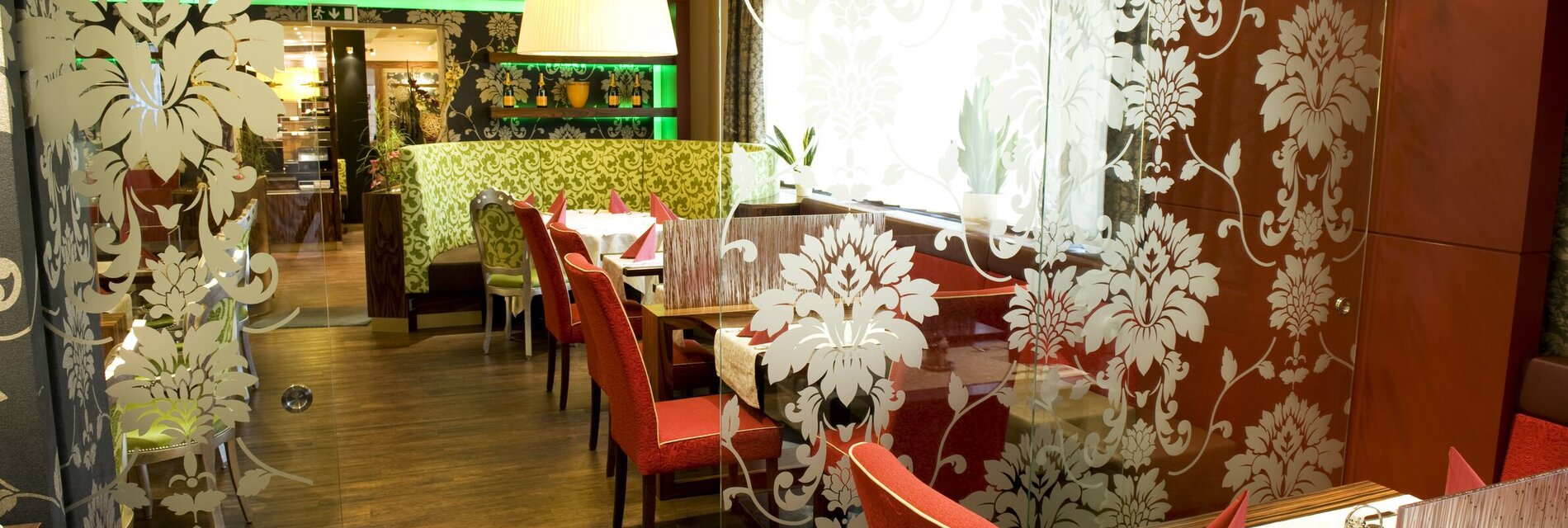 Ein elegantes Restaurant mit roten Stühlen und floralem Design.