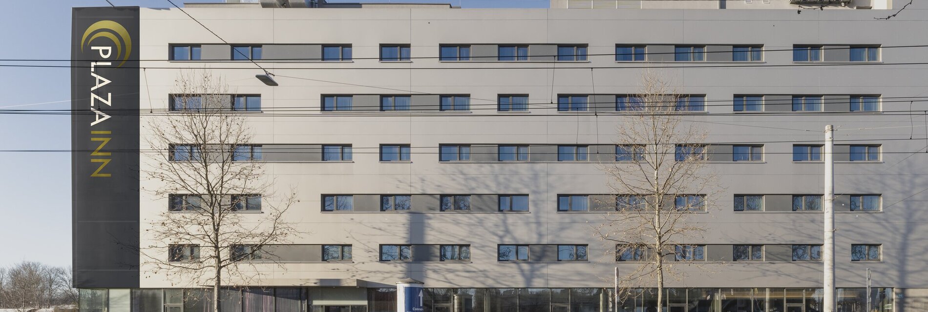 Hotelgebäude mit Glasfront und mehreren Fenstern.
